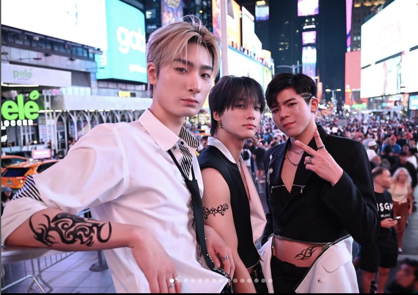 The three members of Big Ocean posing sitting on a brown leather posing backstage.